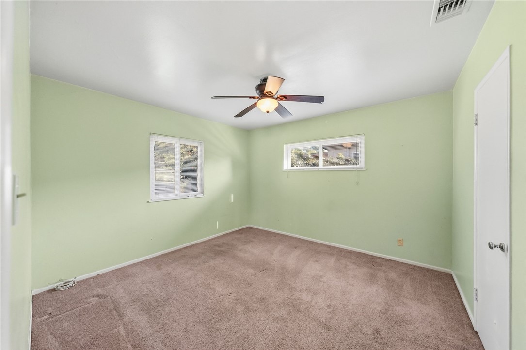3075 David Street Riverside, CA 92506 - Photo 17 of 40 Bright bedroom with soft wall color, ceiling fan, and multiple windows for comfortable everyday living.