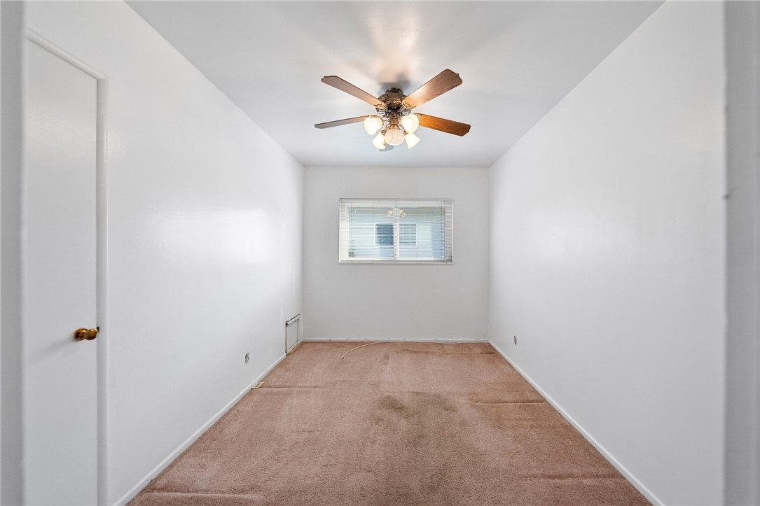 3075 David Street Riverside, CA 92506 - Photo 21 of 40 Cozy room with neutral walls, ceiling fan lighting, and a wide window for natural light.