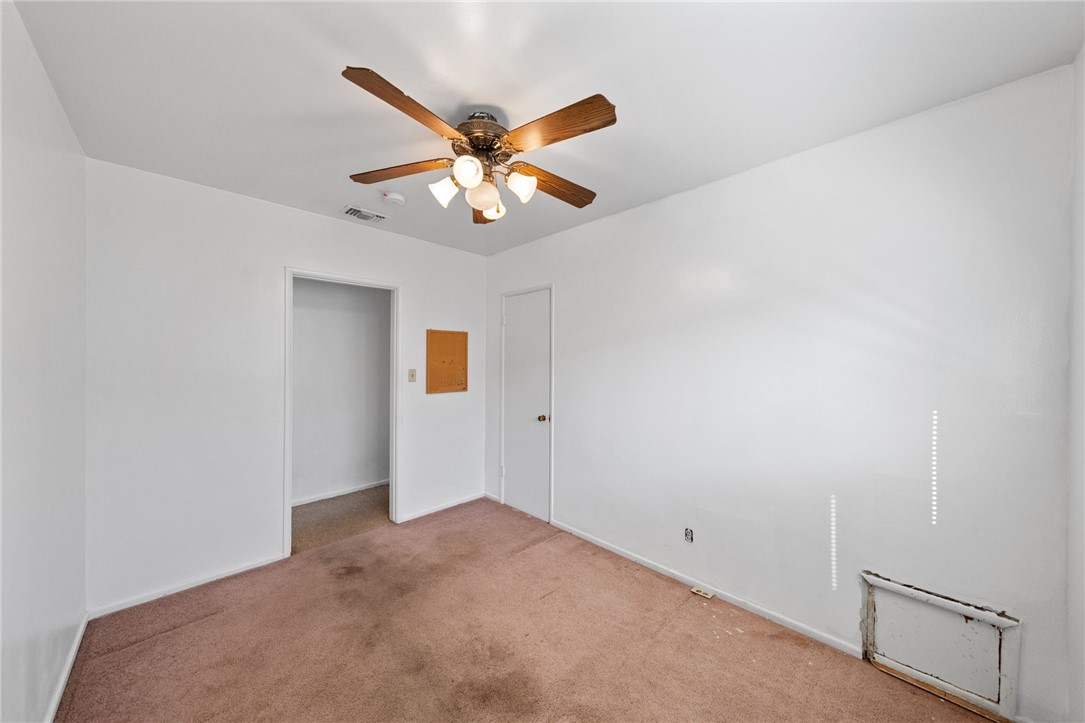 3075 David Street Riverside, CA 92506 - Photo 22 of 40 Bright bedroom with fresh white walls, ceiling fan, and a wide window for natural light.