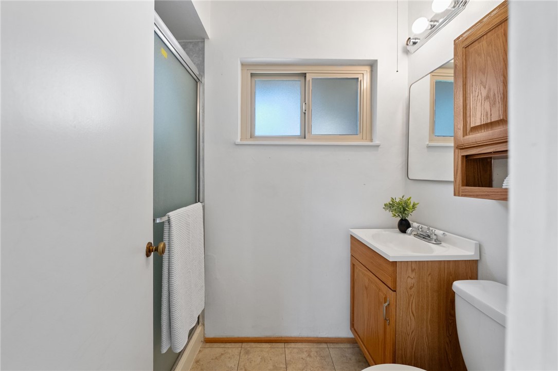 3075 David Street Riverside, CA 92506 - Photo 23 of 40 Clean, functional bath with a tub/shower enclosure, single-sink vanity, and overhead lighting.