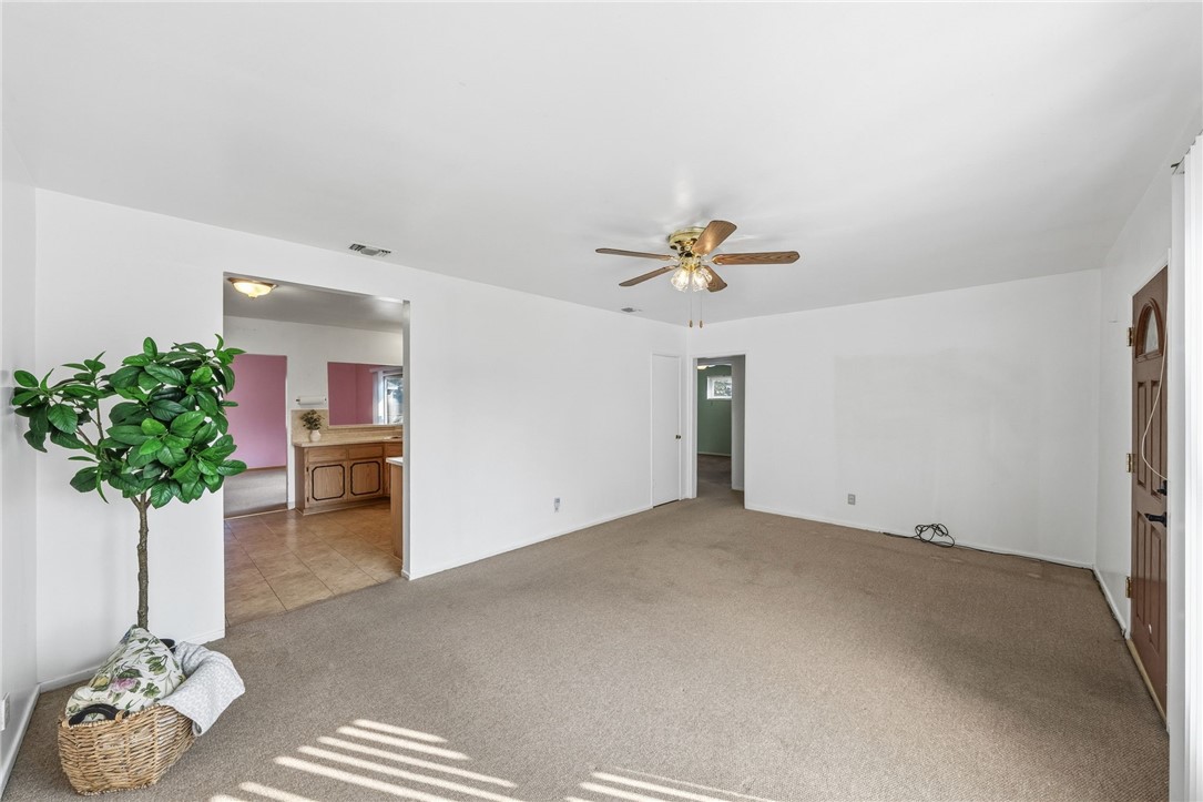 3075 David Street Riverside, CA 92506 - Photo 6 of 40 Bright, open room with ceiling fan and multiple entry points for flexible furniture layout and smooth circulation.