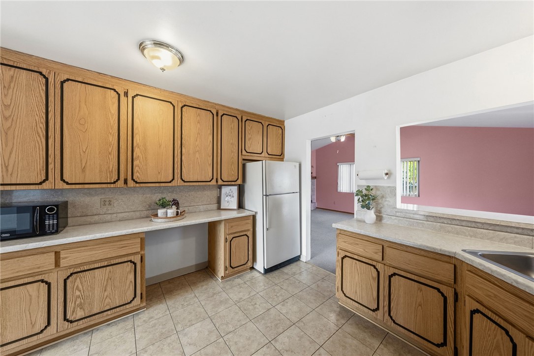 3075 David Street Riverside, CA 92506 - Photo 9 of 40 Spacious kitchen with abundant wood cabinetry, generous counter space, and a convenient pass-through to the adjacent living area.
