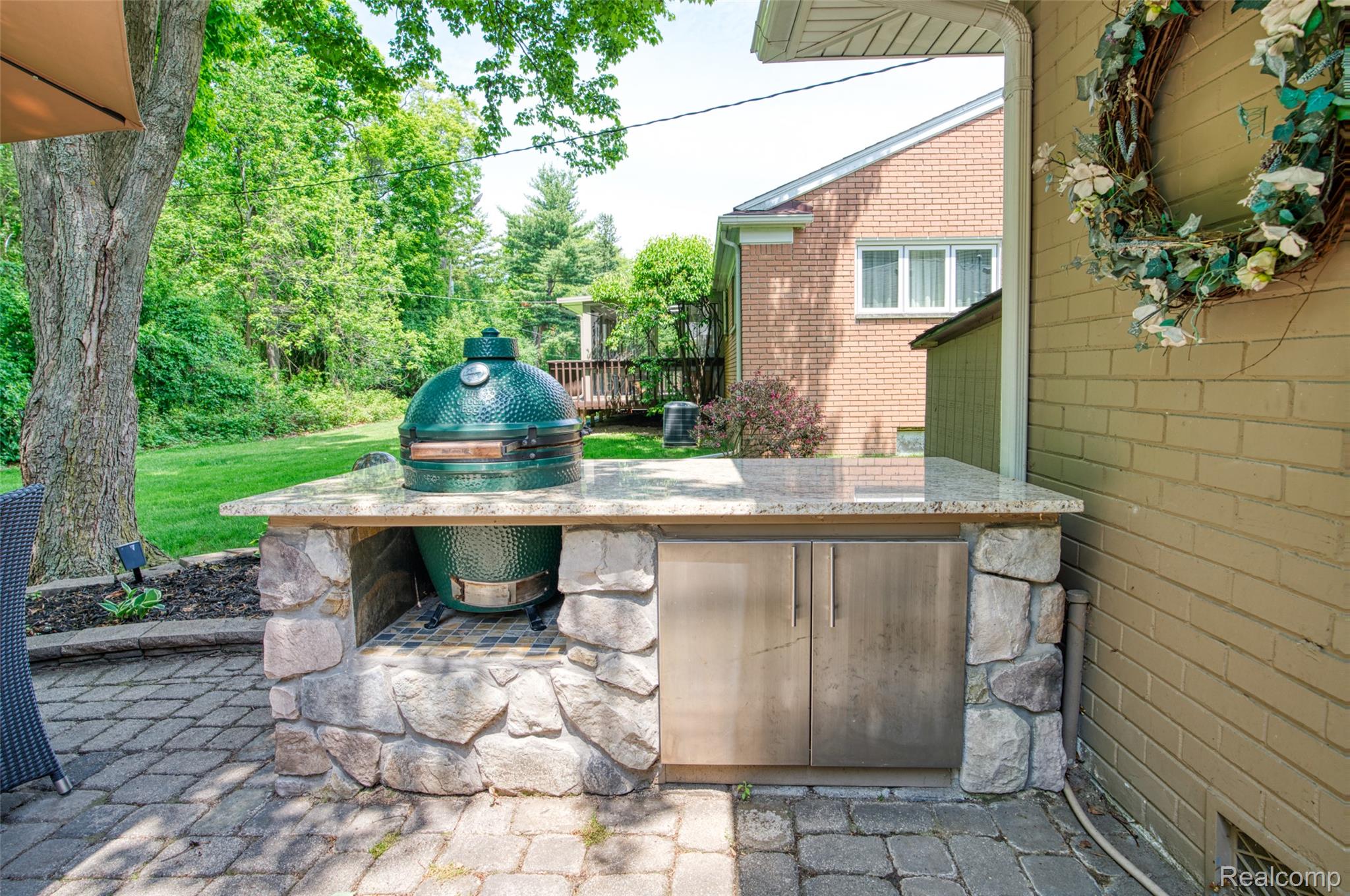 2172 Devonshire Road Bloomfield Hills, MI 48302 - Photo 35 of 45 Outdoor kitchen featuring stone facade, light-toned countertop, and stainless steel cabinetry