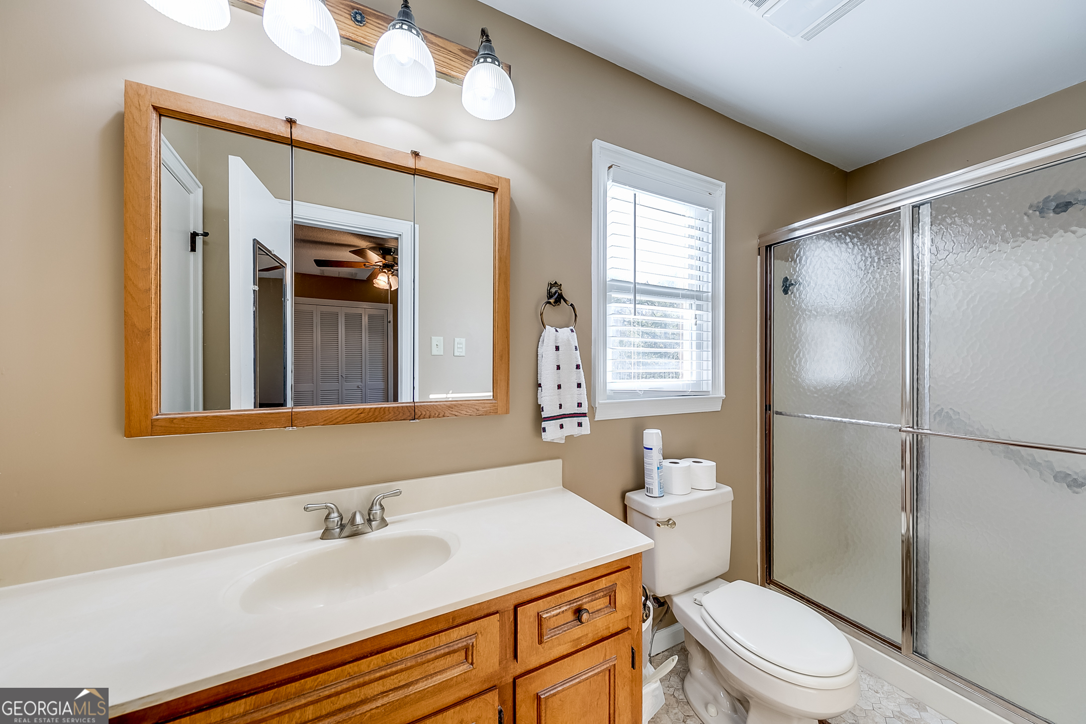1174 Hospital Road Commerce, GA 30529 - Photo 19 of 40 a bathroom with a granite countertop sink toilet a mirror a vanity and shower