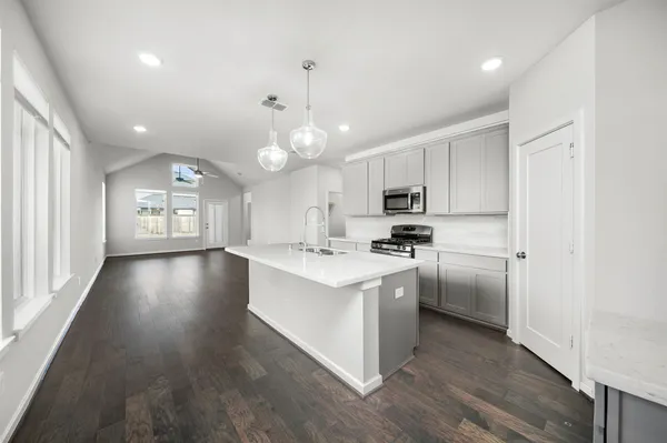 a kitchen with stainless steel appliances a sink stove and cabinets