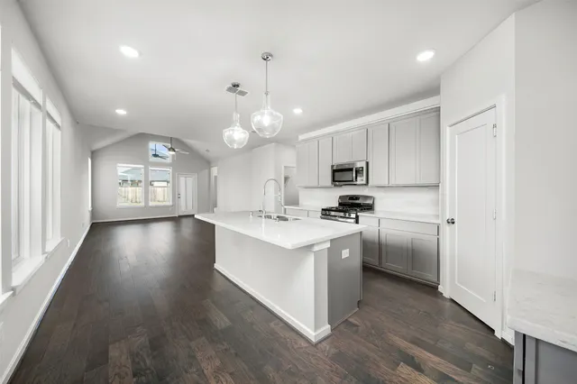 a kitchen with stainless steel appliances a sink stove and cabinets