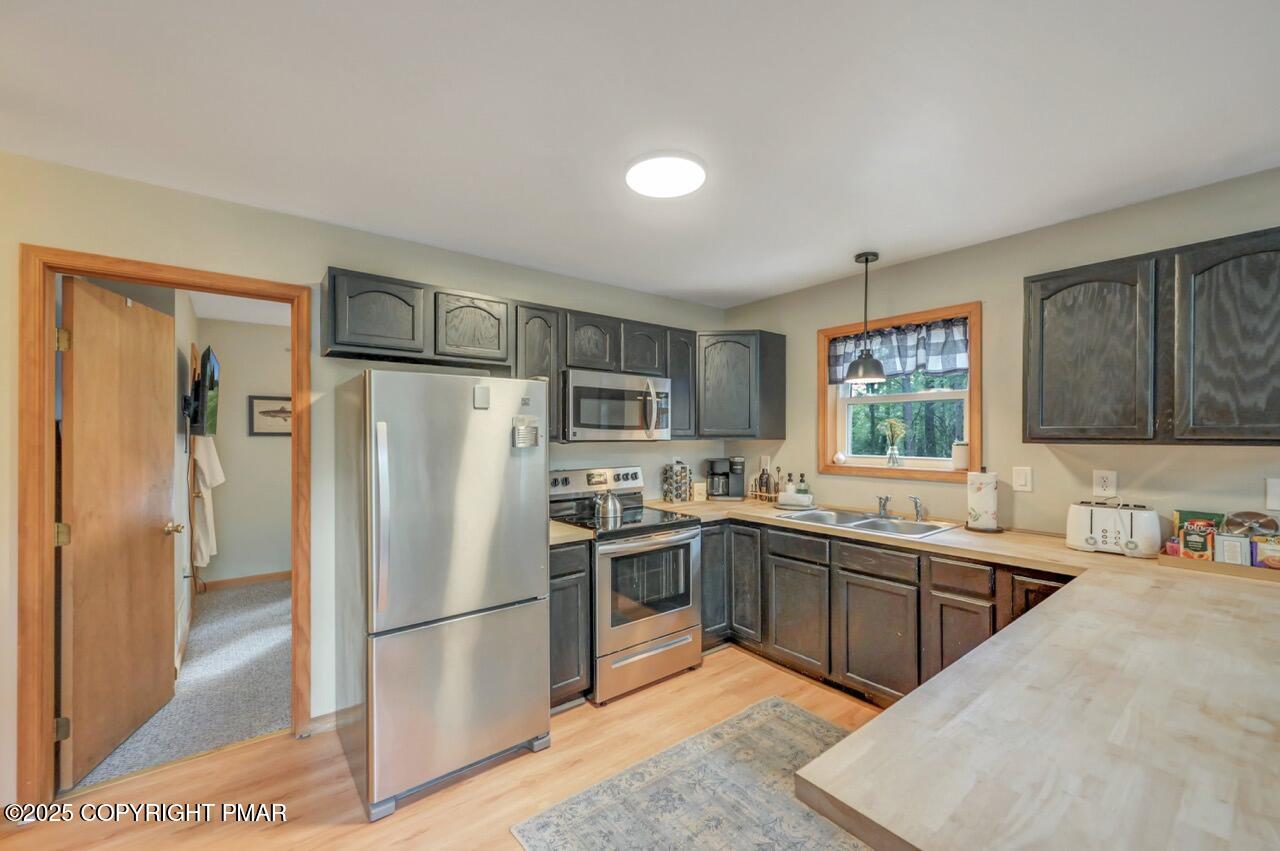 238 King Arthur Road Pocono Lake, PA 18347 - Photo 32 of 95 a kitchen with a sink a refrigerator and cabinets
