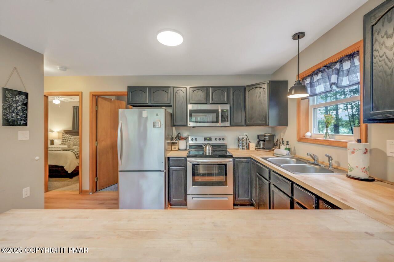 238 King Arthur Road Pocono Lake, PA 18347 - Photo 33 of 95 a kitchen with stainless steel appliances granite countertop a refrigerator a sink dishwasher a stove with wooden cabinets and floor