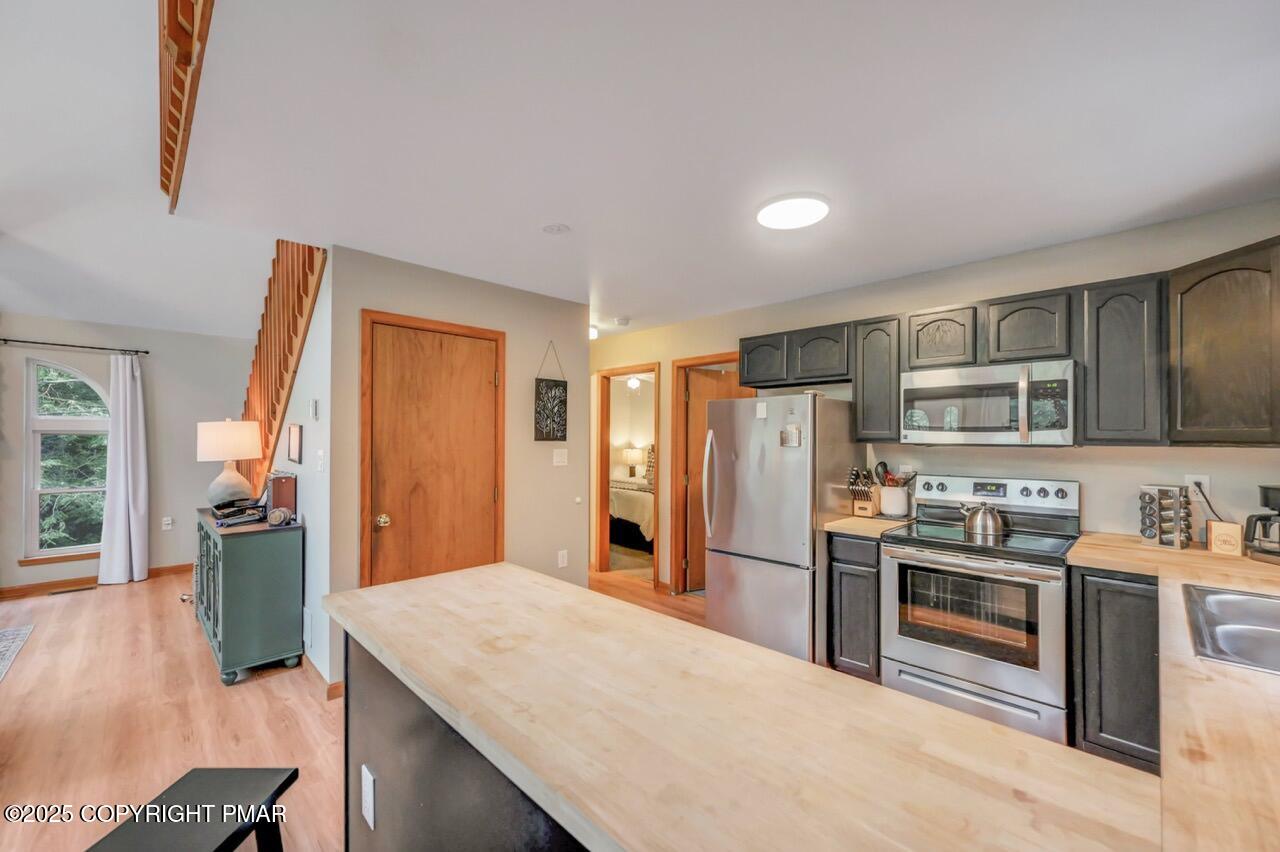 238 King Arthur Road Pocono Lake, PA 18347 - Photo 34 of 95 a kitchen with stainless steel appliances kitchen island granite countertop a refrigerator a stove oven a sink with island and chairs