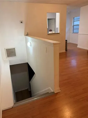 a view of an empty room with wooden floor