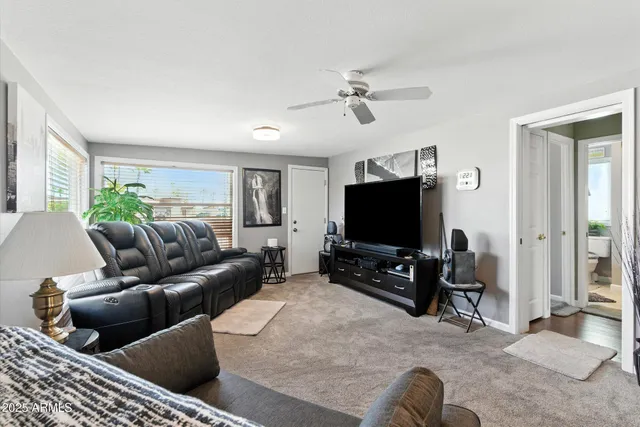 a living room with furniture ceiling fan and a window