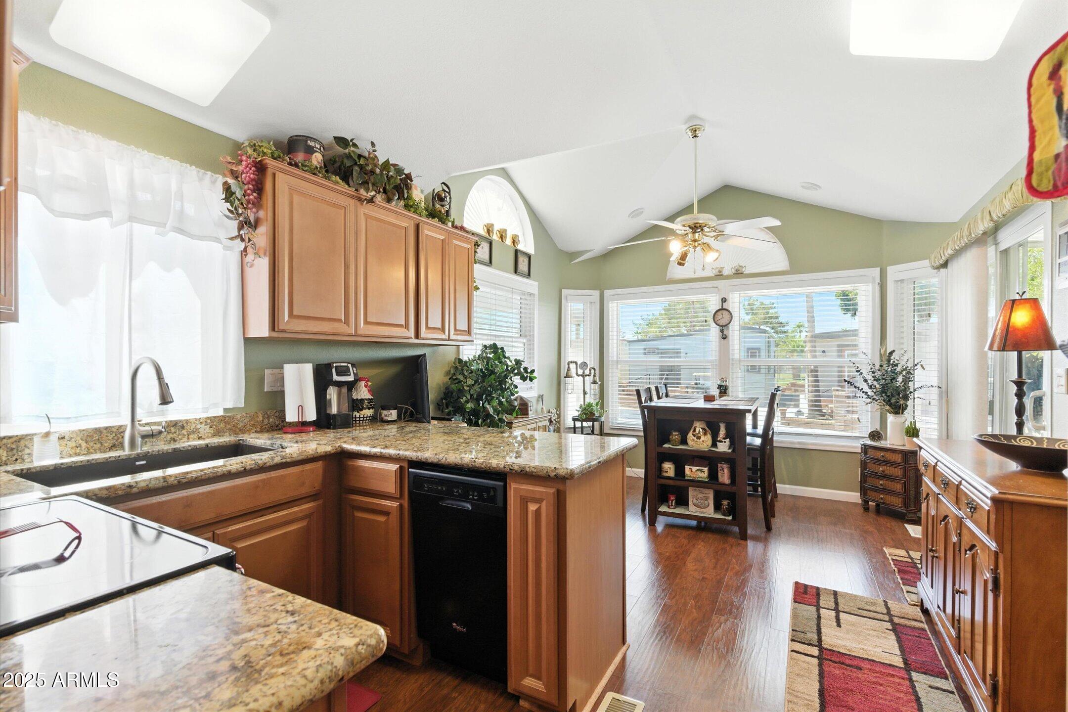 2366 East Pima Avenue Apache Junction, AZ 85119 - Photo 6 of 22 a kitchen with stainless steel appliances granite countertop sink stove and wooden cabinets