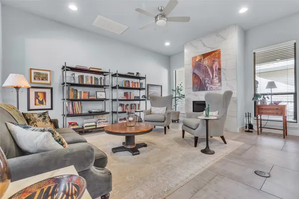 a living room with furniture a rug and a book shelf