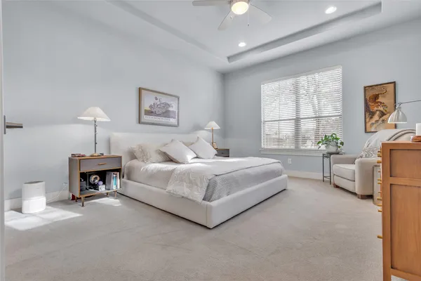 a spacious bedroom with a bed a couch and a window