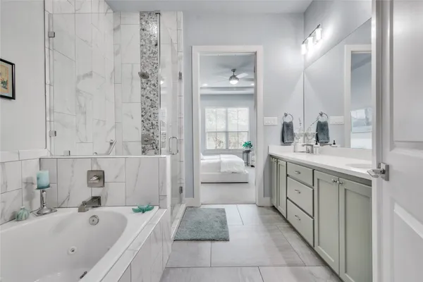 a bathroom with a tub sink and mirror