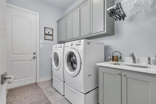 a utility room with sink dryer and washer