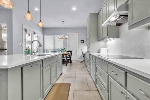 a large white kitchen with lots of counter space and a sink