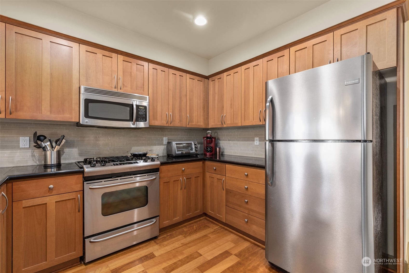 2115 201st Place Southeast, Unit D1 Bothell, WA 98012 - Photo 11 of 33 a kitchen with stainless steel appliances granite countertop a refrigerator stove a sink dishwasher and microwave