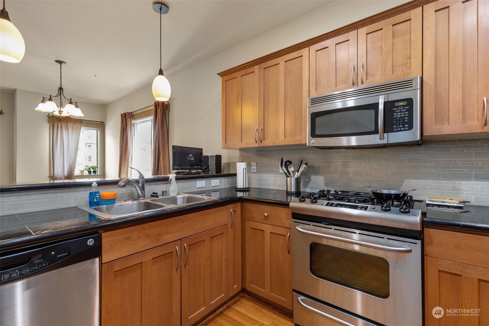2115 201st Place Southeast, Unit D1 Bothell, WA 98012 - Photo 13 of 33 a kitchen with stainless steel appliances granite countertop a sink stove and microwave