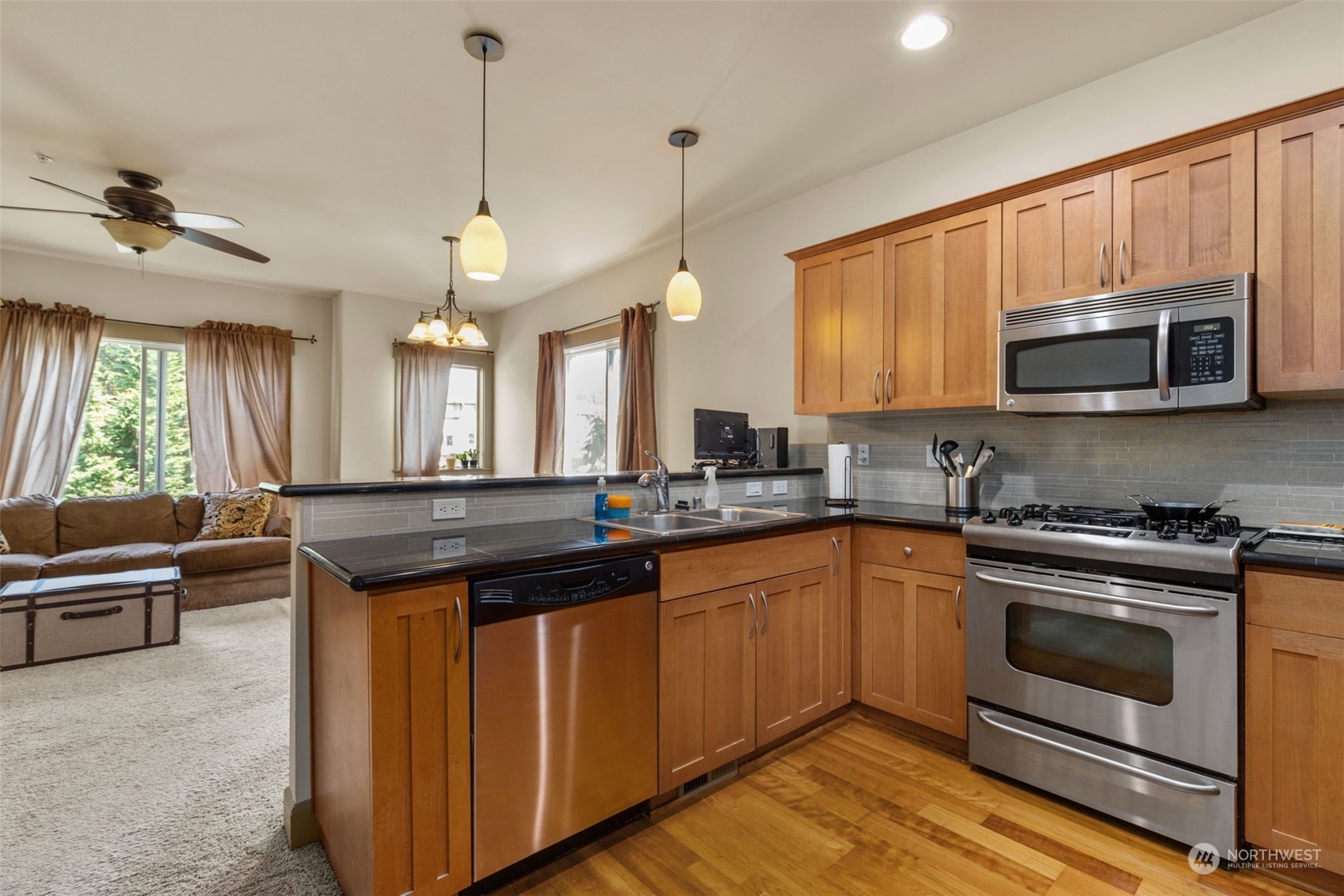 2115 201st Place Southeast, Unit D1 Bothell, WA 98012 - Photo 10 of 33 a kitchen with stainless steel appliances granite countertop a stove a sink and a microwave