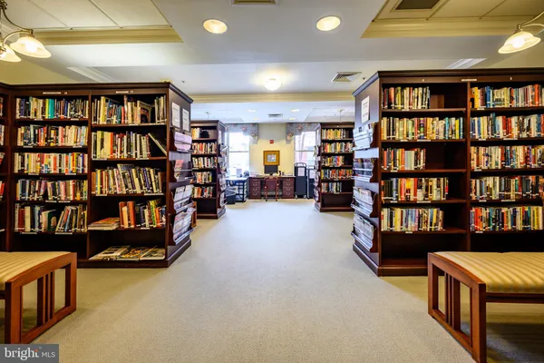 a living room with furniture and a book shelf