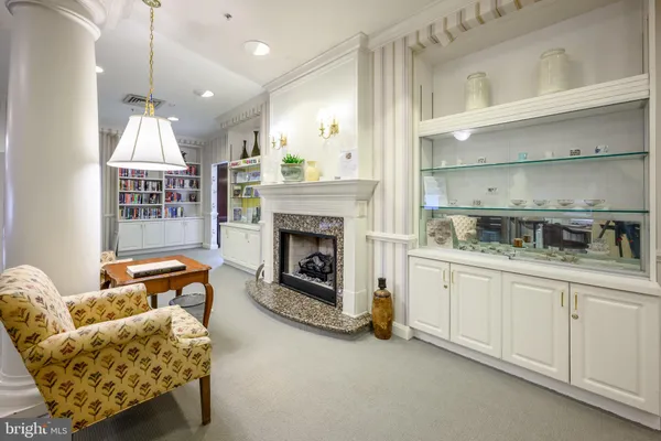 a living room with furniture a fireplace and kitchen view