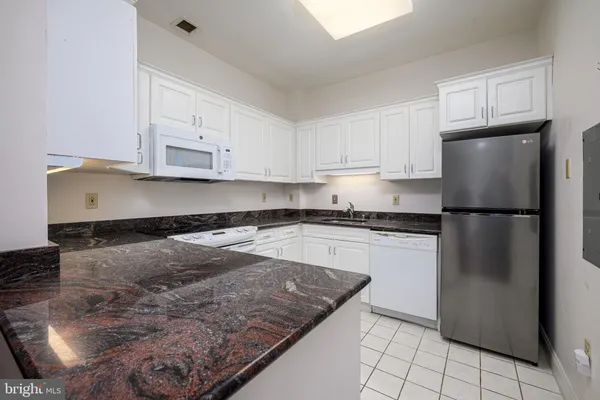 a kitchen with a refrigerator sink and cabinets