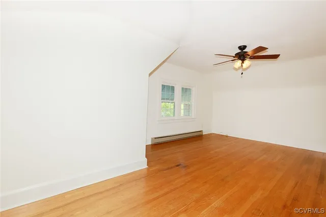 a view of a room with a wooden floor and a ceiling fan