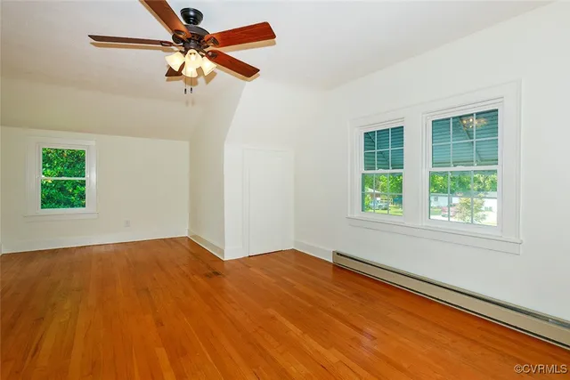 an empty room with a window and a ceiling fan