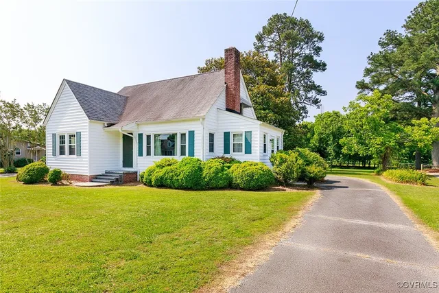 a view of a house with a yard and potted plants