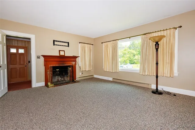 an empty room with windows and fireplace