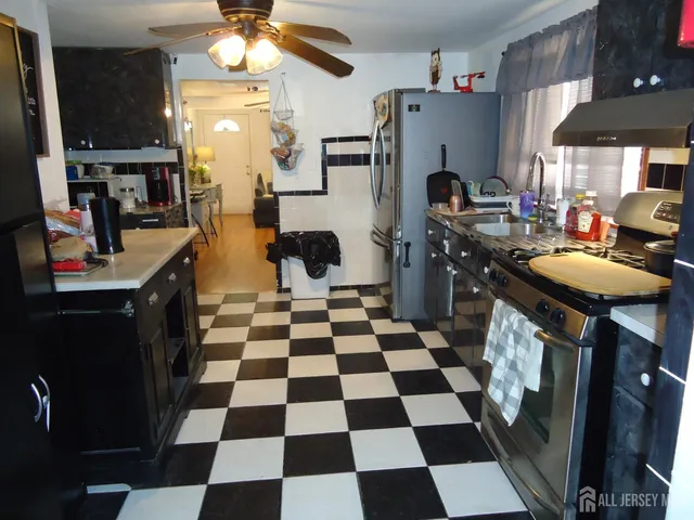 a kitchen with a sink a stove a refrigerator and a dining table with the view of kitchen
