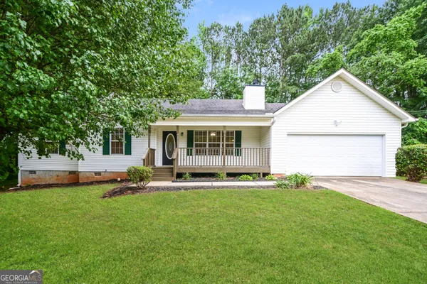 a front view of a house with a yard and trees