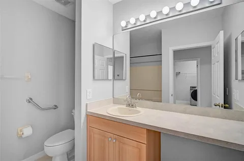 a bathroom with a sink a toilet a mirror and shower