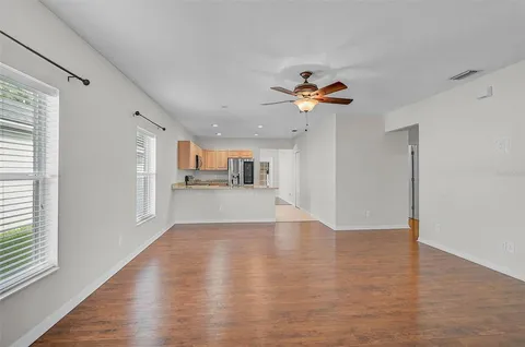 a view of a kitchen with wooden floor and a ceiling fan