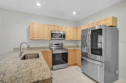 a kitchen with stainless steel appliances granite countertop a refrigerator stove and sink