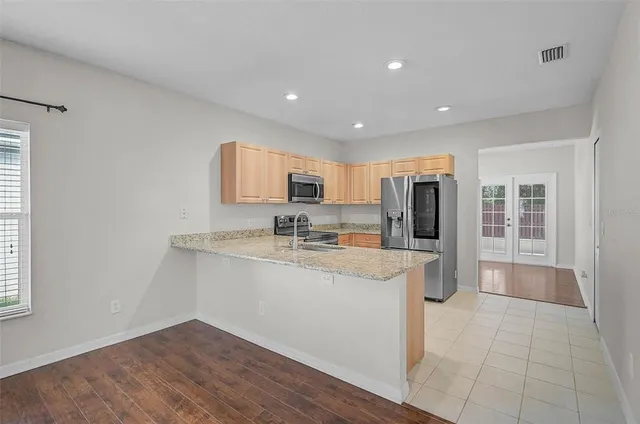 a kitchen with stainless steel appliances granite countertop a refrigerator and a sink