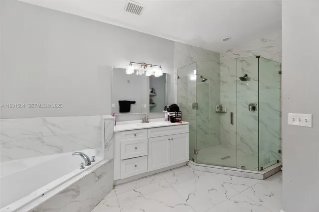 a bathroom with a bathtub shower sink mirror and toilet