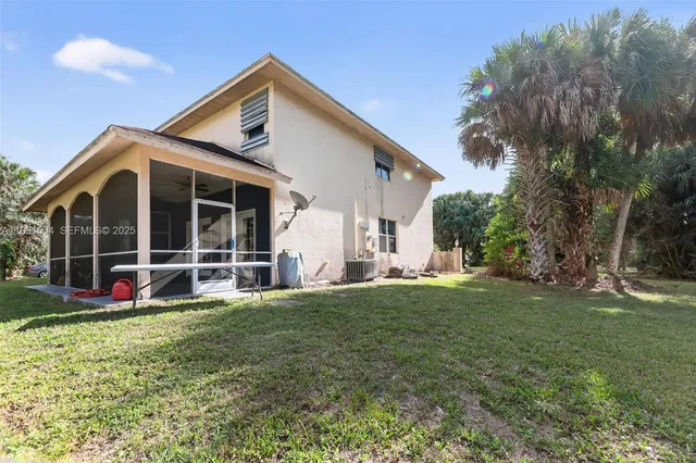 a view of a house with a yard and sitting area