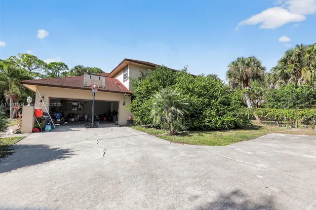 a view of a house with a yard and potted plants