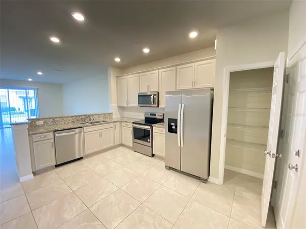 a kitchen with a refrigerator sink and cabinets
