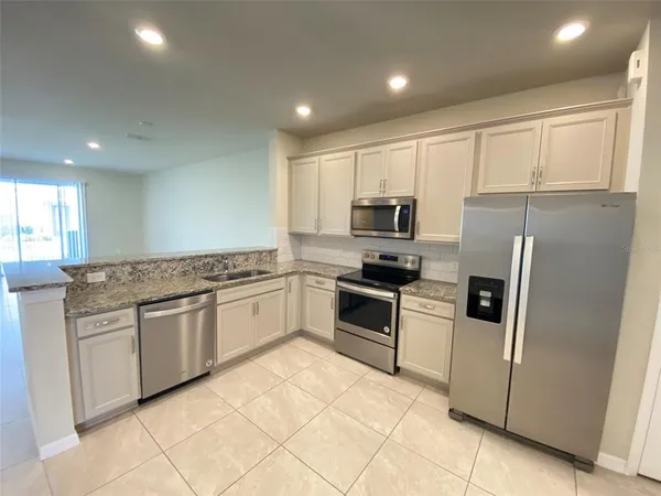 a kitchen with granite countertop cabinets and steel stainless steel appliances