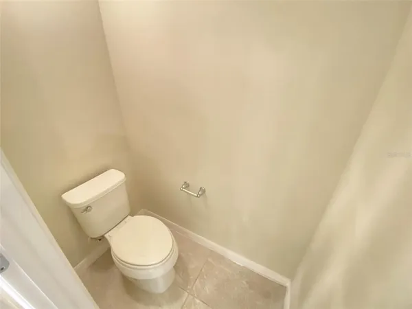 a white toilet sitting next to a white wall
