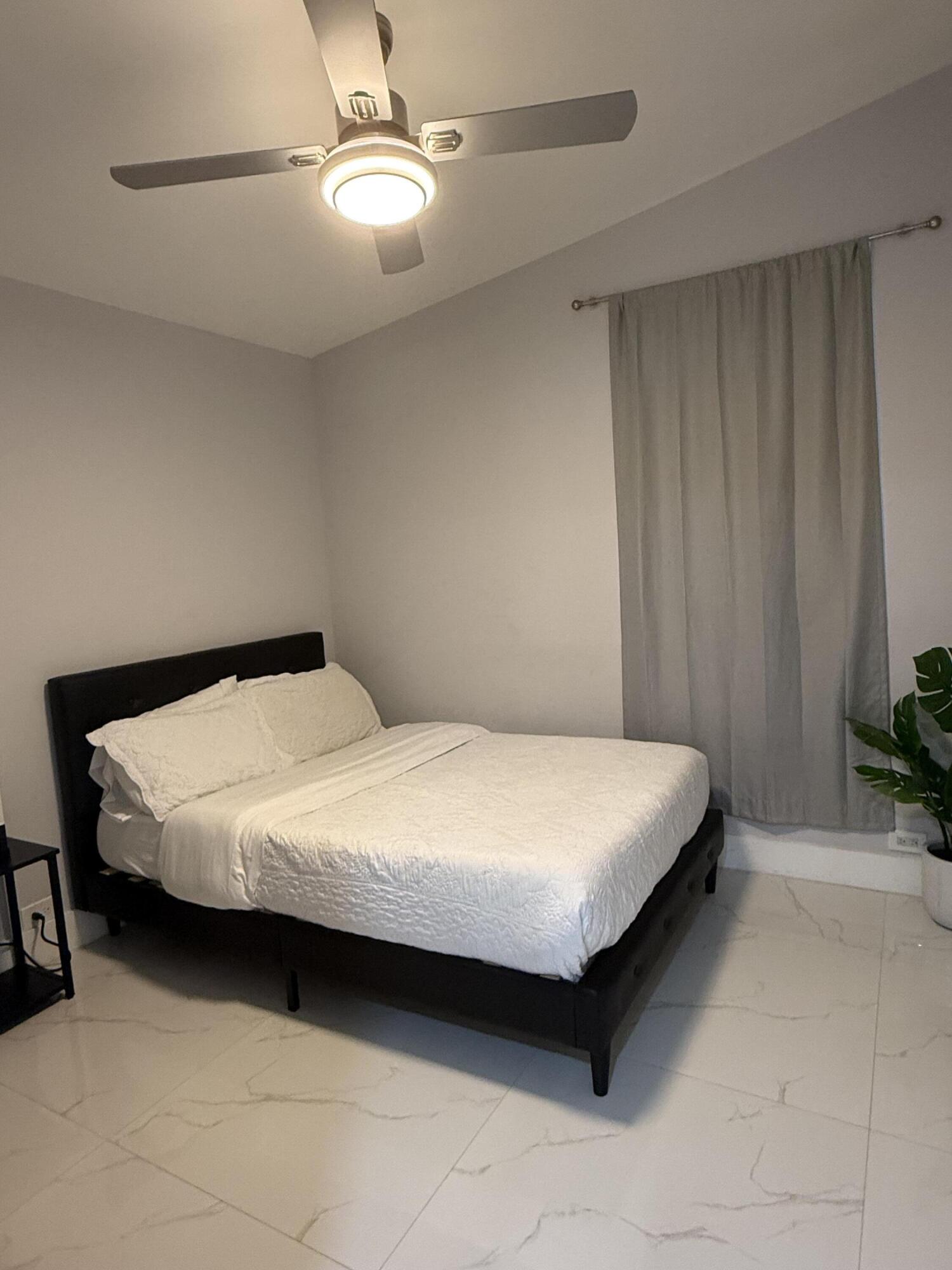 255 Glouchester Street Boca Raton, FL 33487 - Photo 8 of 11 a large bed sitting in a bedroom next to a window