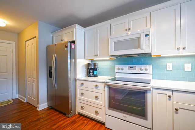 a kitchen with white cabinets and stainless steel appliances