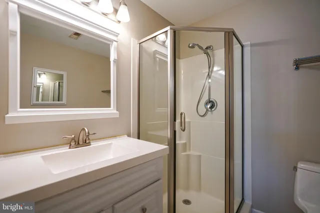a bathroom with a shower sink and mirror