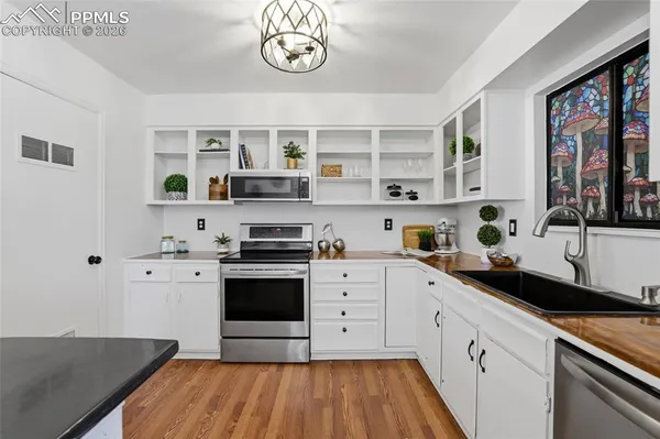 a kitchen with a stove cabinets and a wooden floor