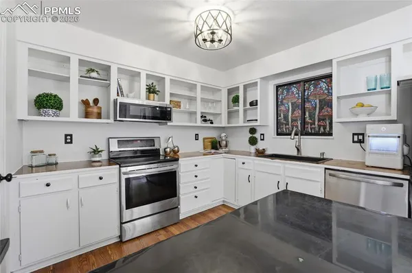 a kitchen with a stove a sink and cabinets