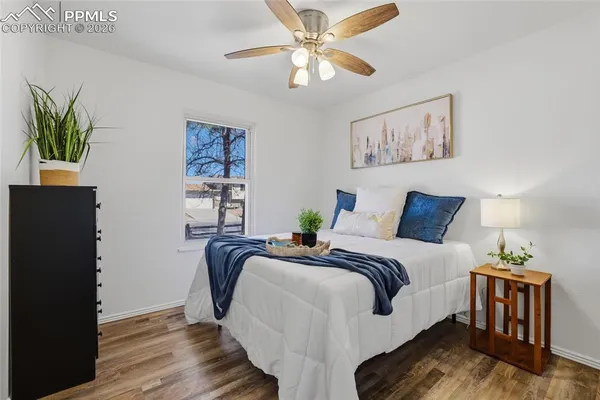 a bedroom with bed and wooden floor