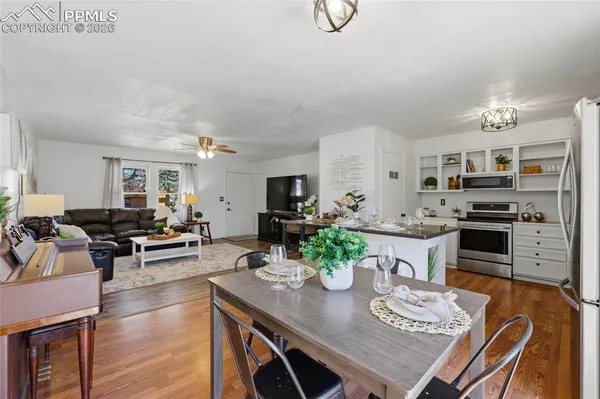 a view of a dining room with furniture a kitchen and chandelier